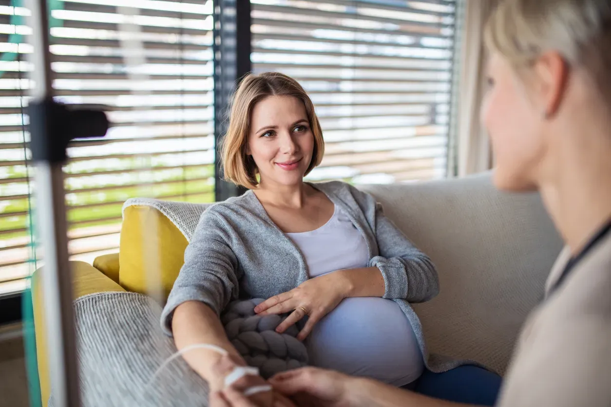 Healthcare professional providing home infusion therapy to patient in comfortable home setting